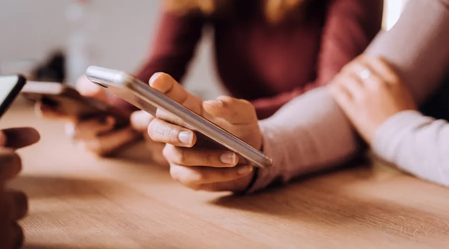 Dos personas interactuando con sus teléfonos inteligentes Dos personas interactuando con sus teléfonos inteligentes