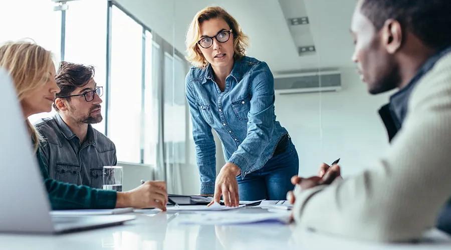 Mujer liderando presentación de negocio en una reunión