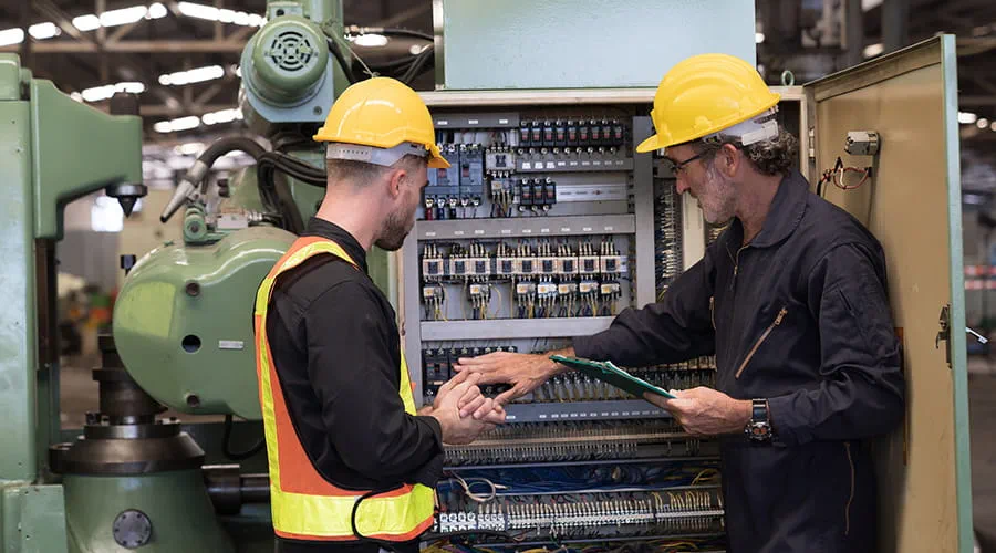 Grupo de trabajadores electricistas que revisan, reparan, mantienen el sistema eléctrico de la máquina