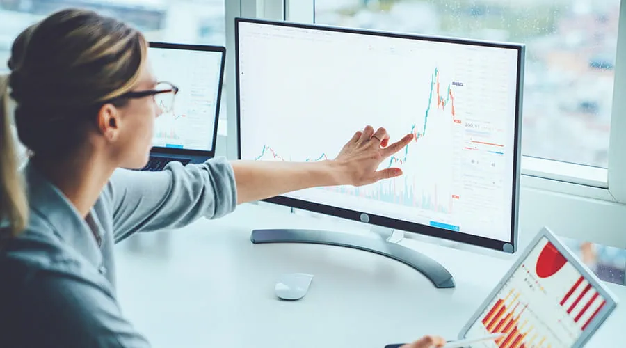 Mujer revisando estudios financieros en una pantalla Mujer revisando estudios financieros en una pantalla
