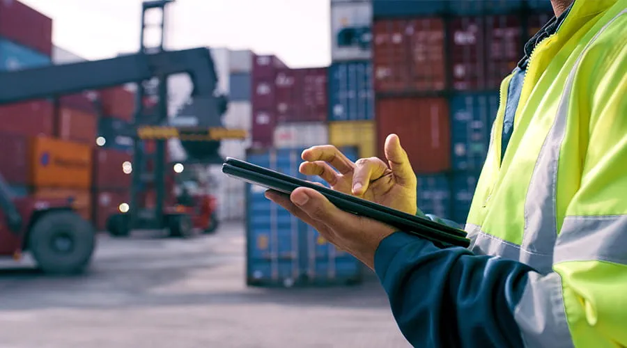 Hombre trabajando con una tablet en entorno puertos Hombre trabajando con una tablet en entorno puertos