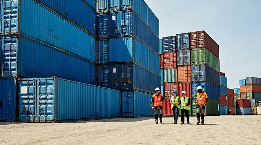 Grupo de personas cerca de contenedores en un puerto Grupo de personas cerca de contenedores en un puerto