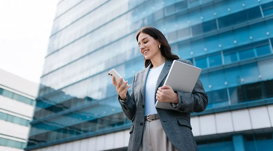 Mujer de negocios sonriente usando un teléfono inteligente