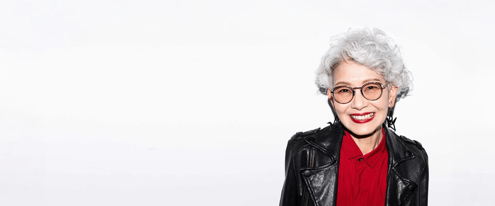 Femme âgée aux cheveux gris souriant avec confiance contre un fond neutre Femme âgée aux cheveux gris souriant avec confiance contre un fond neutre
