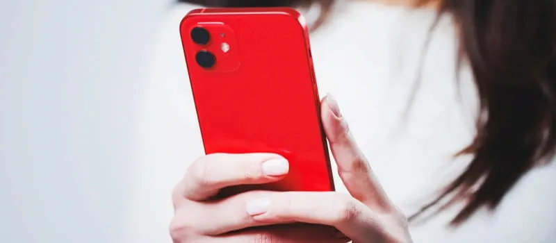 Des mains tenant un smartphone rouge Des mains tenant un smartphone rouge