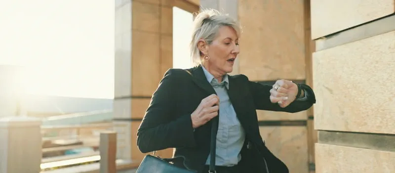 Une femme stressée d'arriver en retard au travail dans un environnement professionnel Une femme stressée d'arriver en retard au travail dans un environnement professionnel