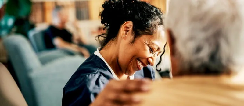 Une soignante souriante communicant avec sa patiente Une soignante souriante communicant avec sa patiente
