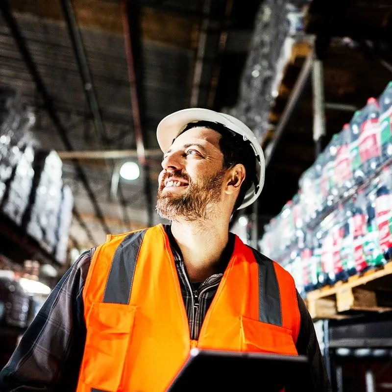 Un homme souriant travaillant sur un site logistique Un homme souriant travaillant sur un site logistique