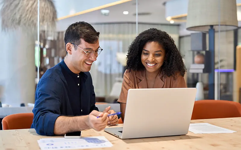Deux salariés à leur ordinateur réalisant une VAE avec Adecco Training