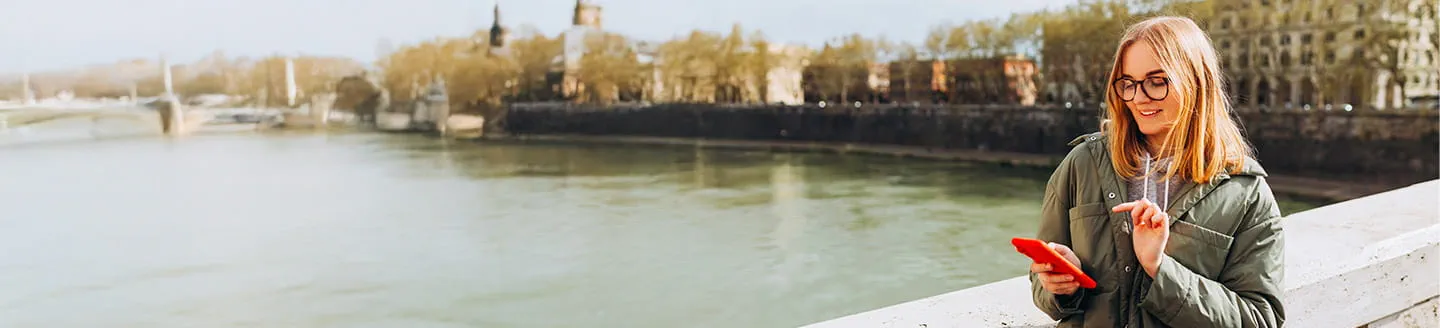 Une candidate souriante recevant un SMS de l’agent IA Adecco Une candidate souriante recevant un SMS de l’agent IA Adecco