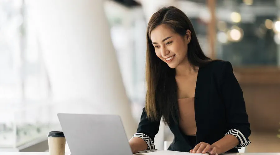 Young female professional working on a laptop at a modern desk Young female professional working on a laptop at a modern desk