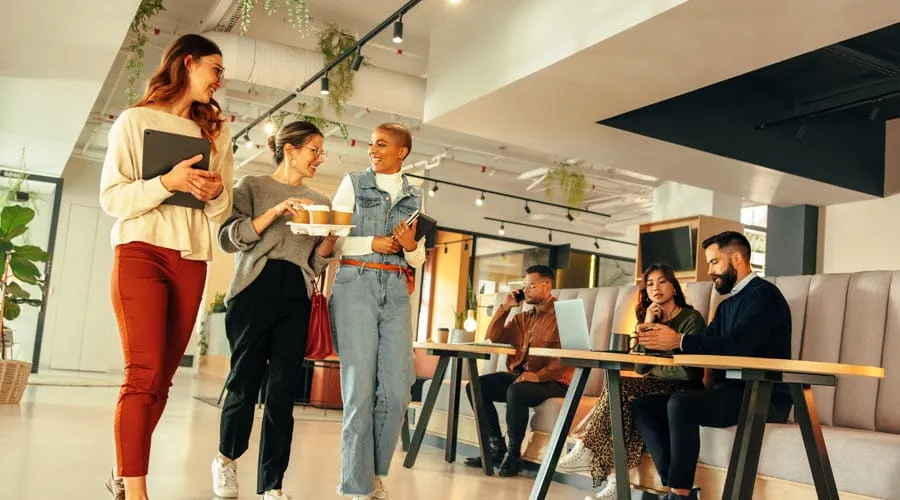 Female coworkers getting  coffee and having a casual  chat
