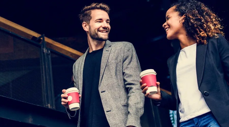 Two coworkers having a coffee break and sharing ideas Two coworkers having a coffee break and sharing ideas