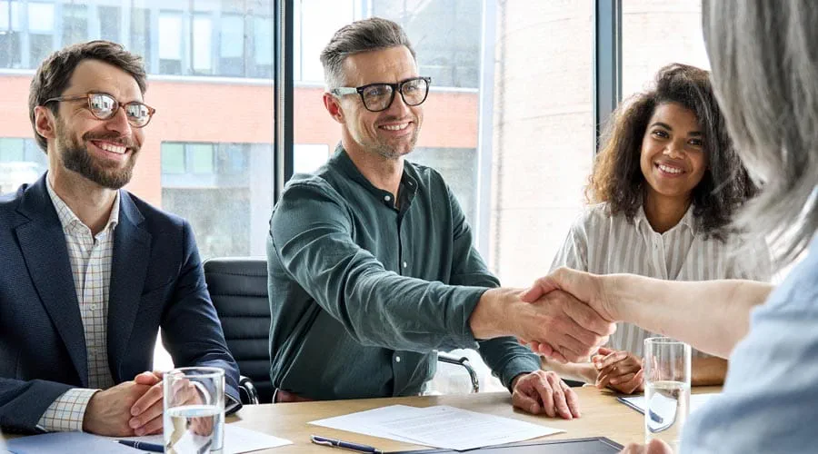 Candidate and interviewer shaking hands during a group intervie