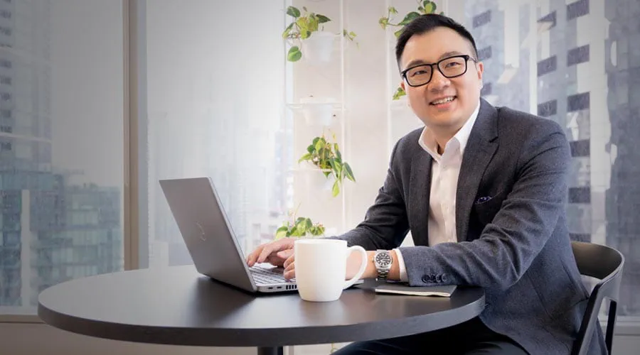 Smiling professional working on a laptop in a modern office Smiling professional working on a laptop in a modern office