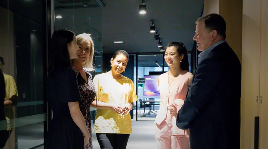 Four colleagues having a discussion in a hallway. Four colleagues having a discussion in a hallway.