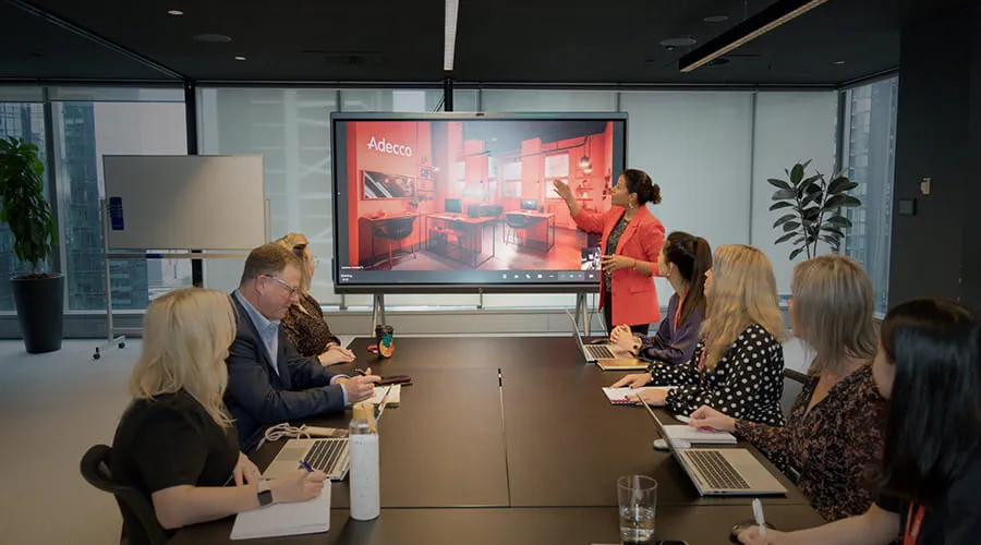 A group of staff seated around a table in a meeting room. A group of staff seated around a table in a meeting room.