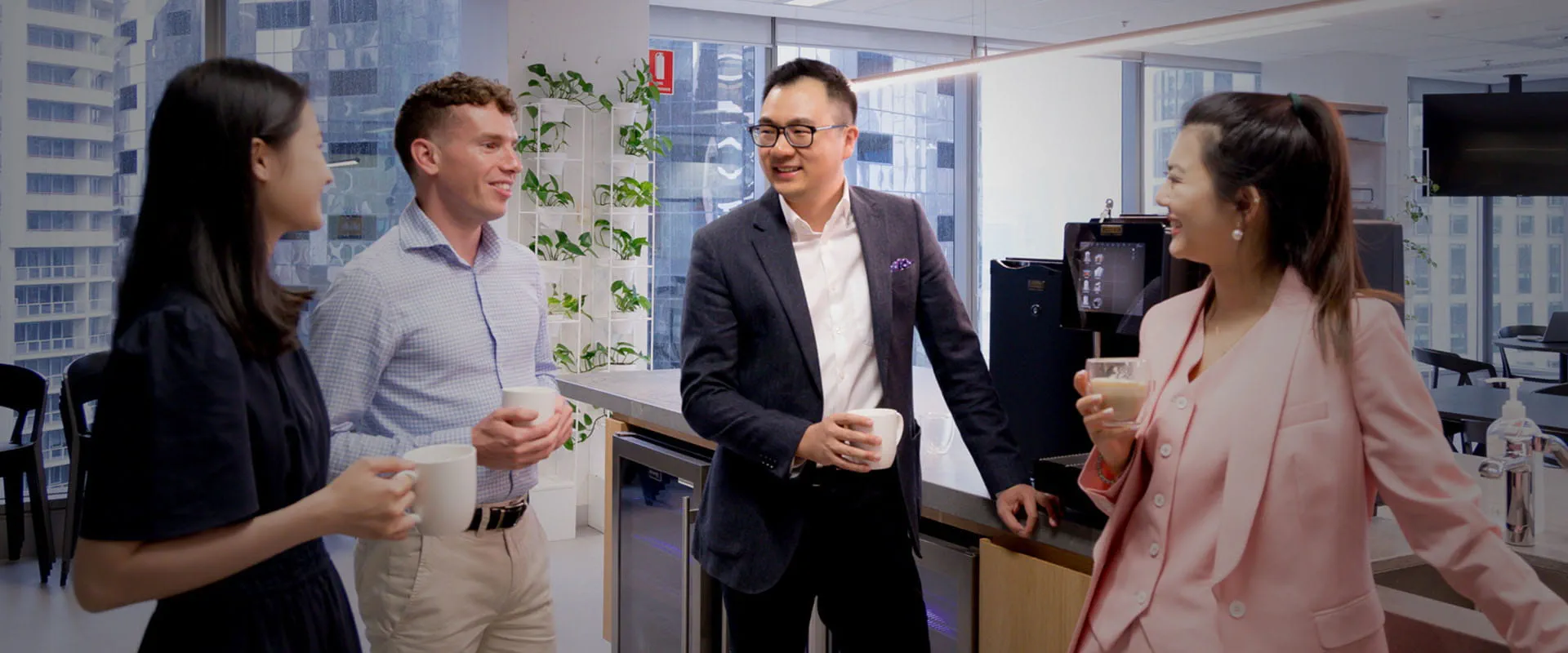 Four staff in discussion in a pantry. Four staff in discussion in a pantry.