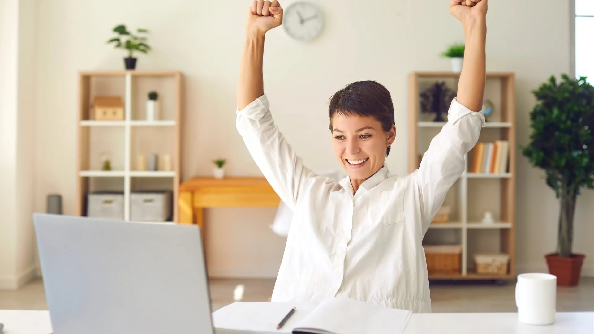 femme professionnelle levant les mains devant son ordinateur portable