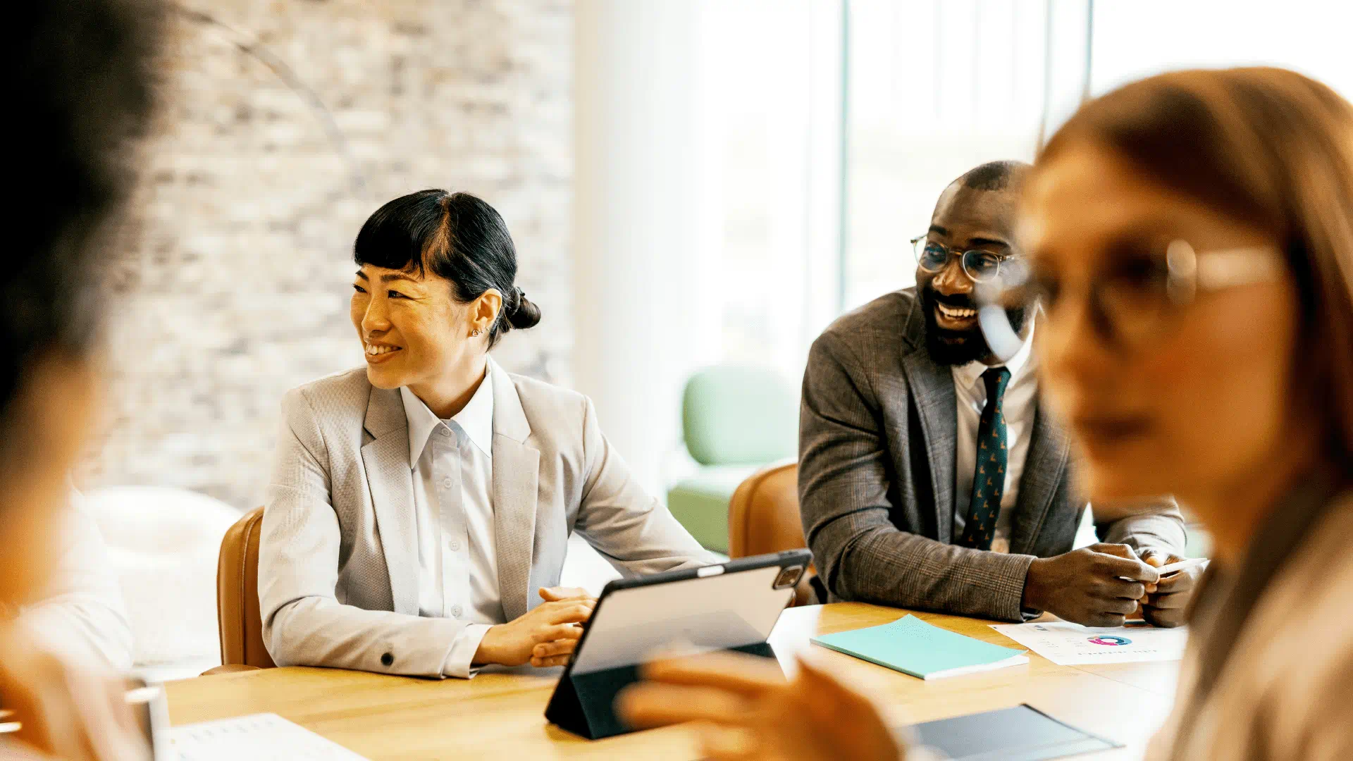 people working at a desk in a common work setting and smiling people working at a desk in a common work setting and smiling