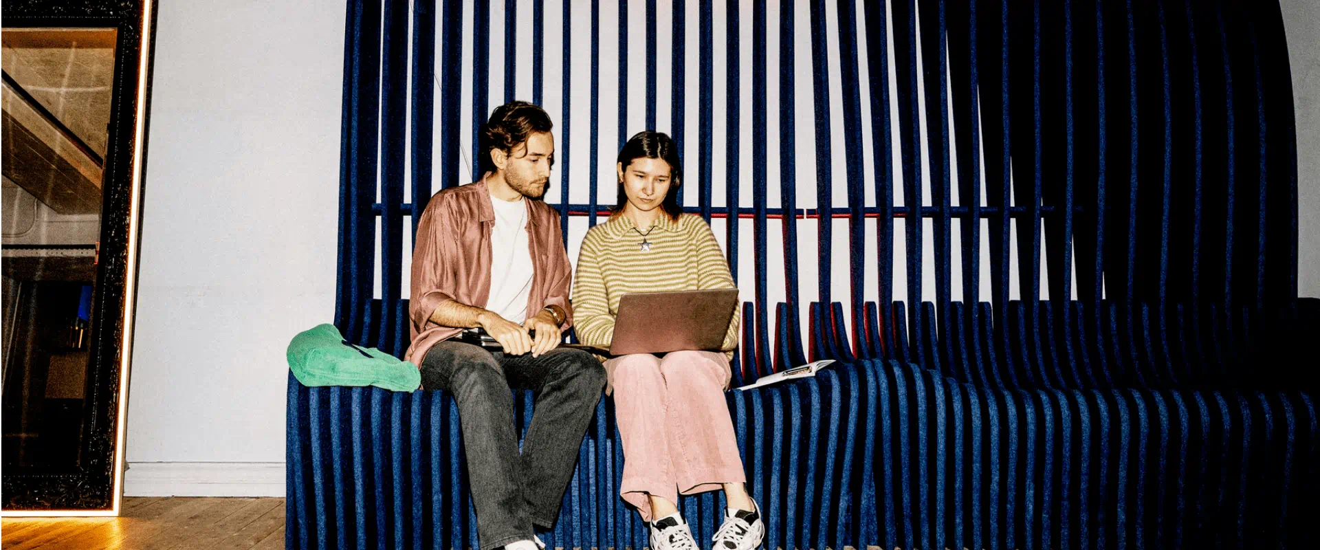Two people sitting with laptops in modern workspace Two people sitting with laptops in modern workspace