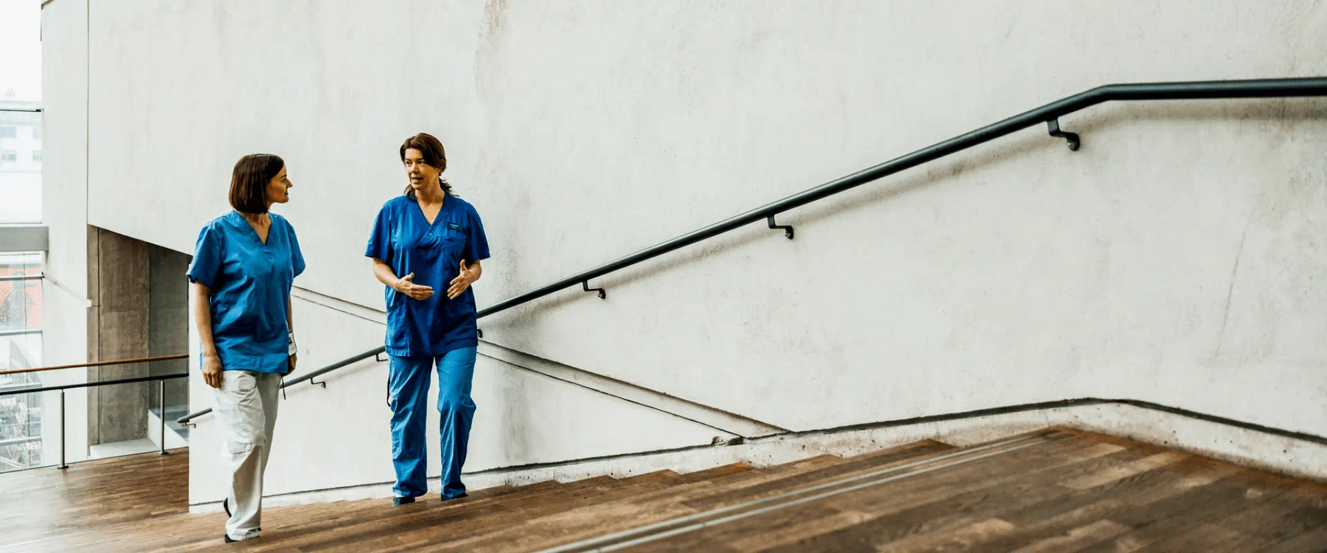 Two healthcare workers walking outside building Two healthcare workers walking outside building