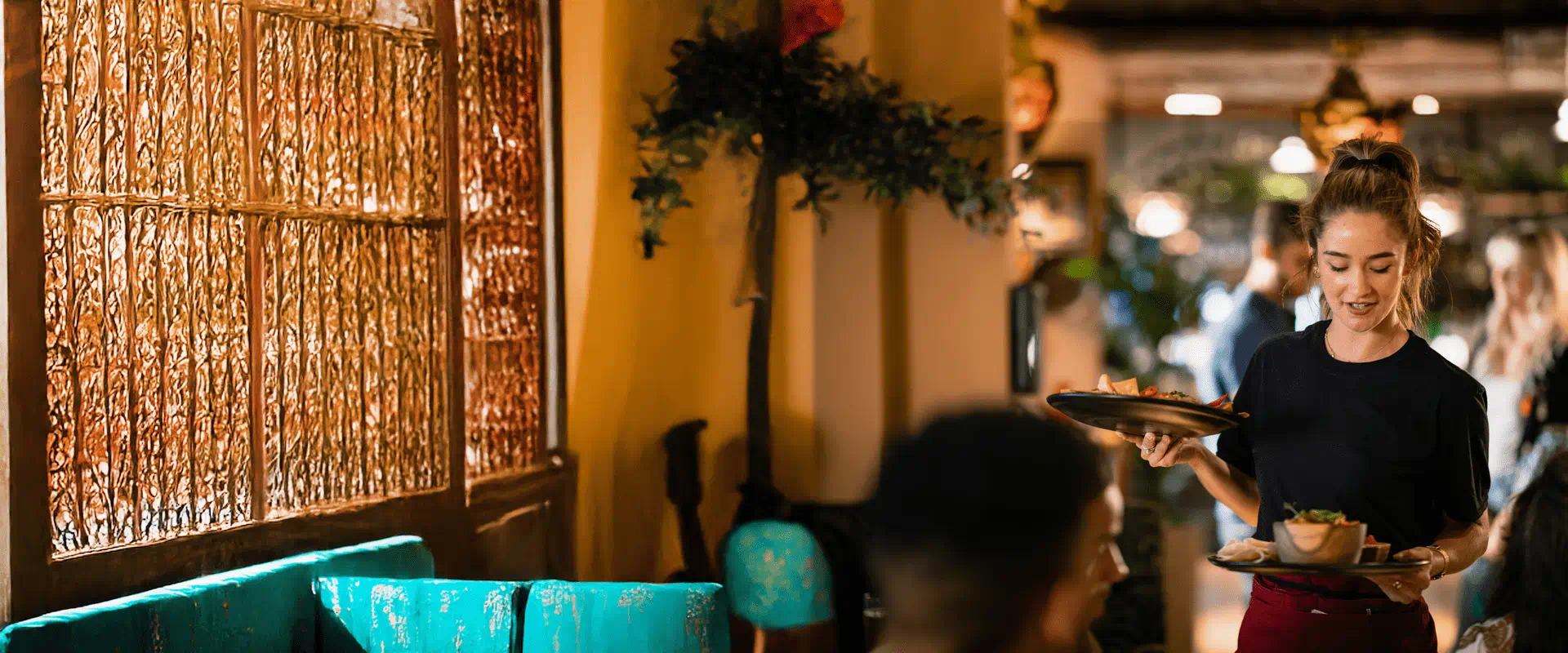 Una cameriera prende un’ordinazione da clienti in un ristorante. Una cameriera prende un’ordinazione da clienti in un ristorante.