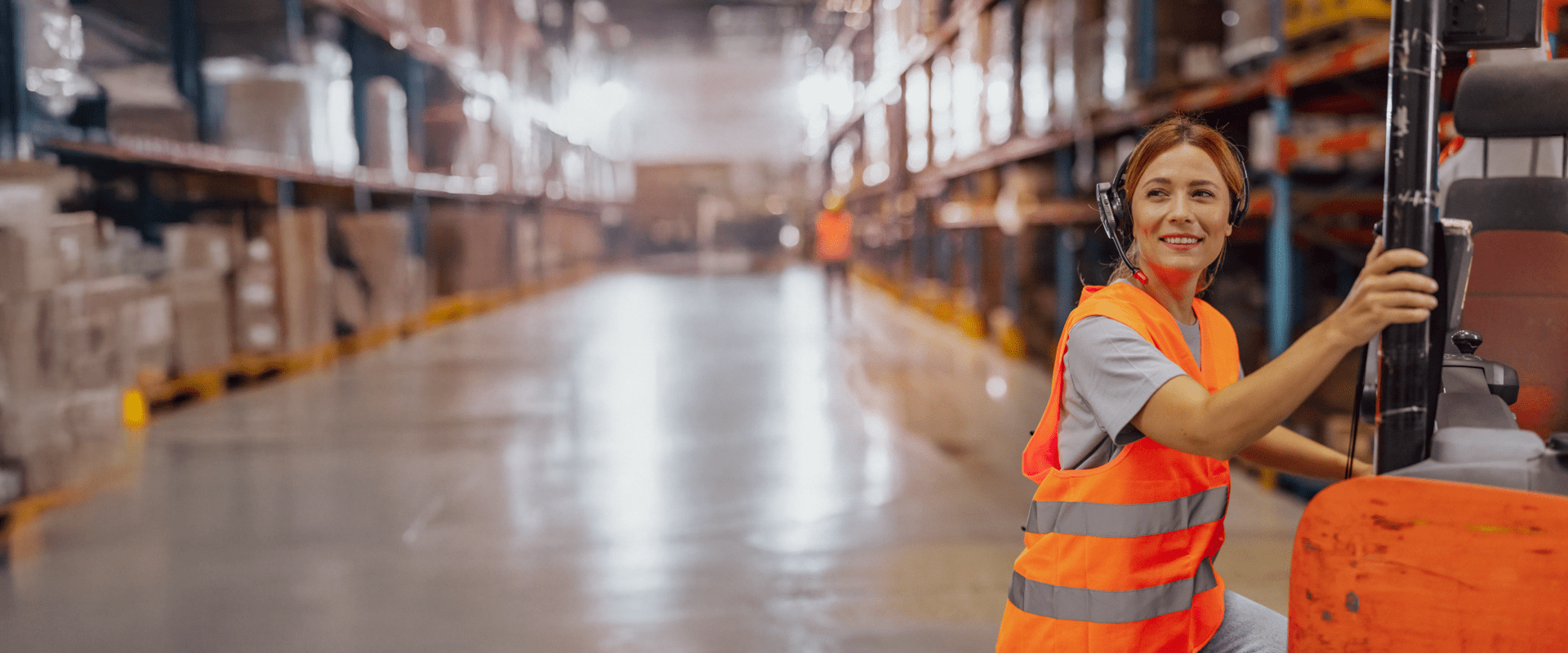 Eine Logistikmitarbeiterin trägt eine orangefarbene Sicherheitsweste in einem Lager oder Industriegebiet. Eine Logistikmitarbeiterin trägt eine orangefarbene Sicherheitsweste in einem Lager oder Industriegebiet.