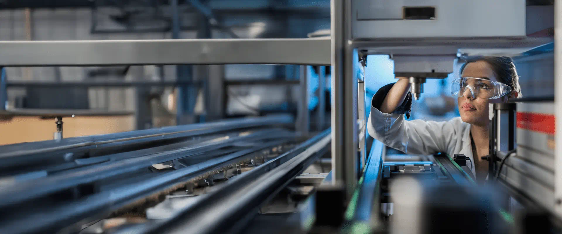 A woman wearing safety glasses working in the industrial sector.