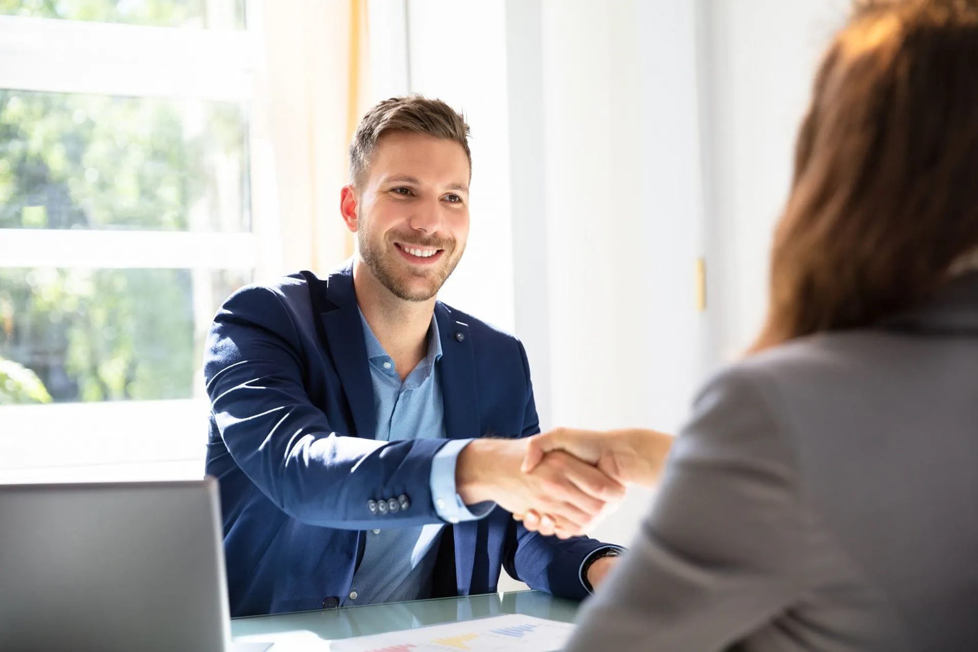 A consultant greets a female client in a friendly manner. A consultant greets a female client in a friendly manner.