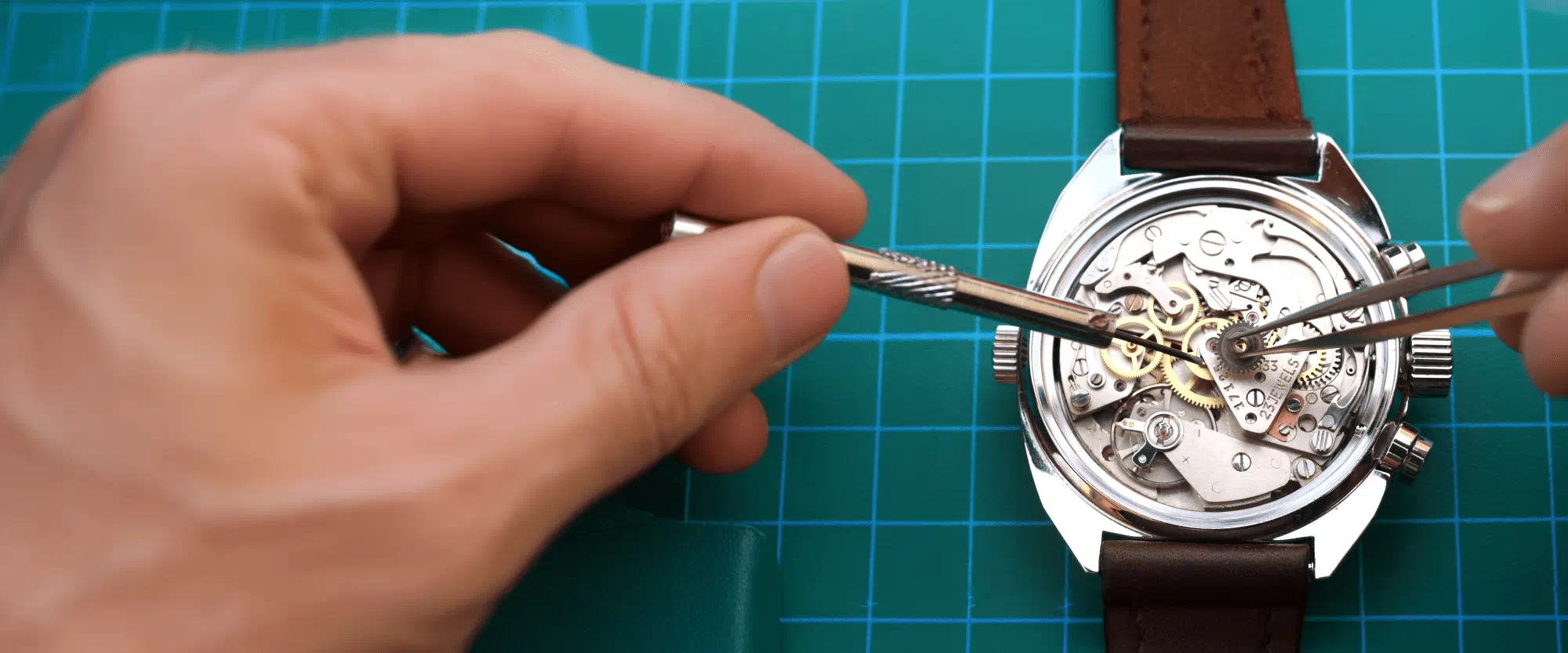 Hände, die ein Uhrwerk zusammensetzen Hände, die ein Uhrwerk zusammensetzen