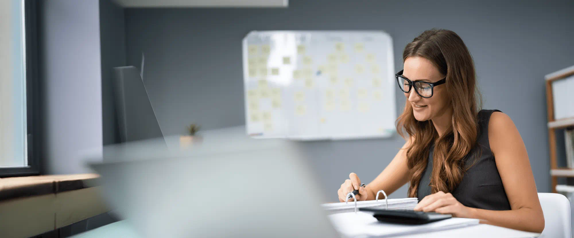 A woman working diligently in an office. A woman working diligently in an office.