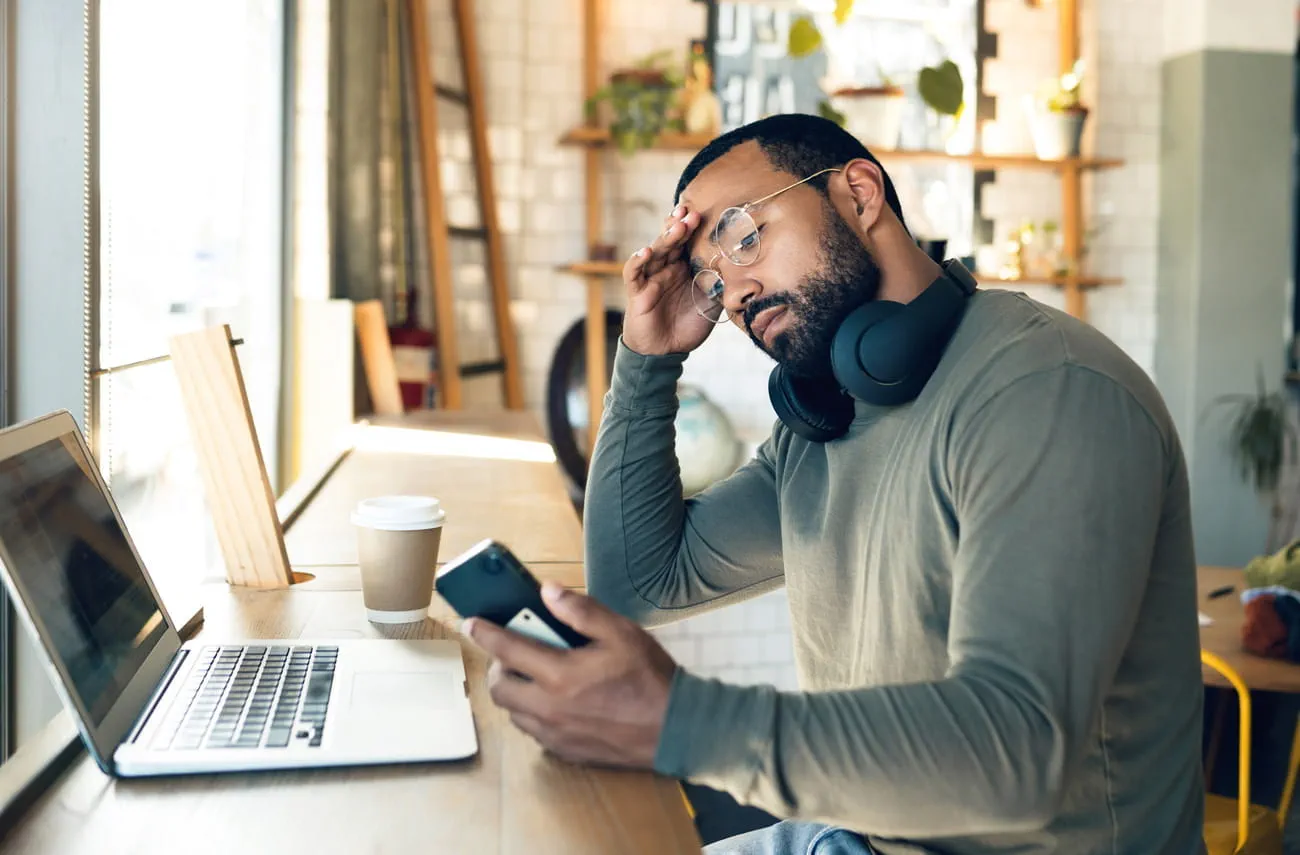 erschoepfter-student-schaut-auf-sein-handy