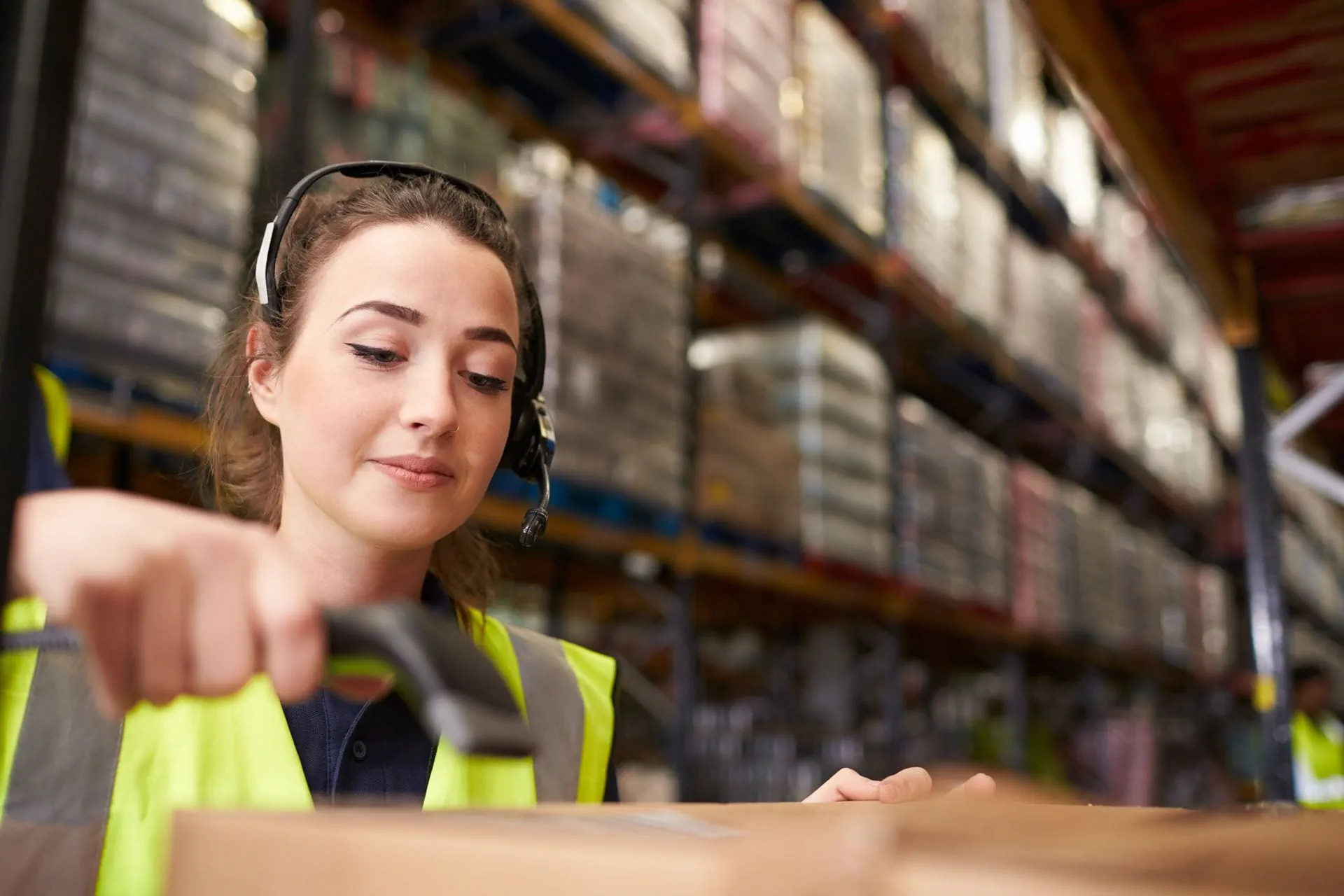 Lagermitarbeiterin scannt Ware in einem Logistiklager