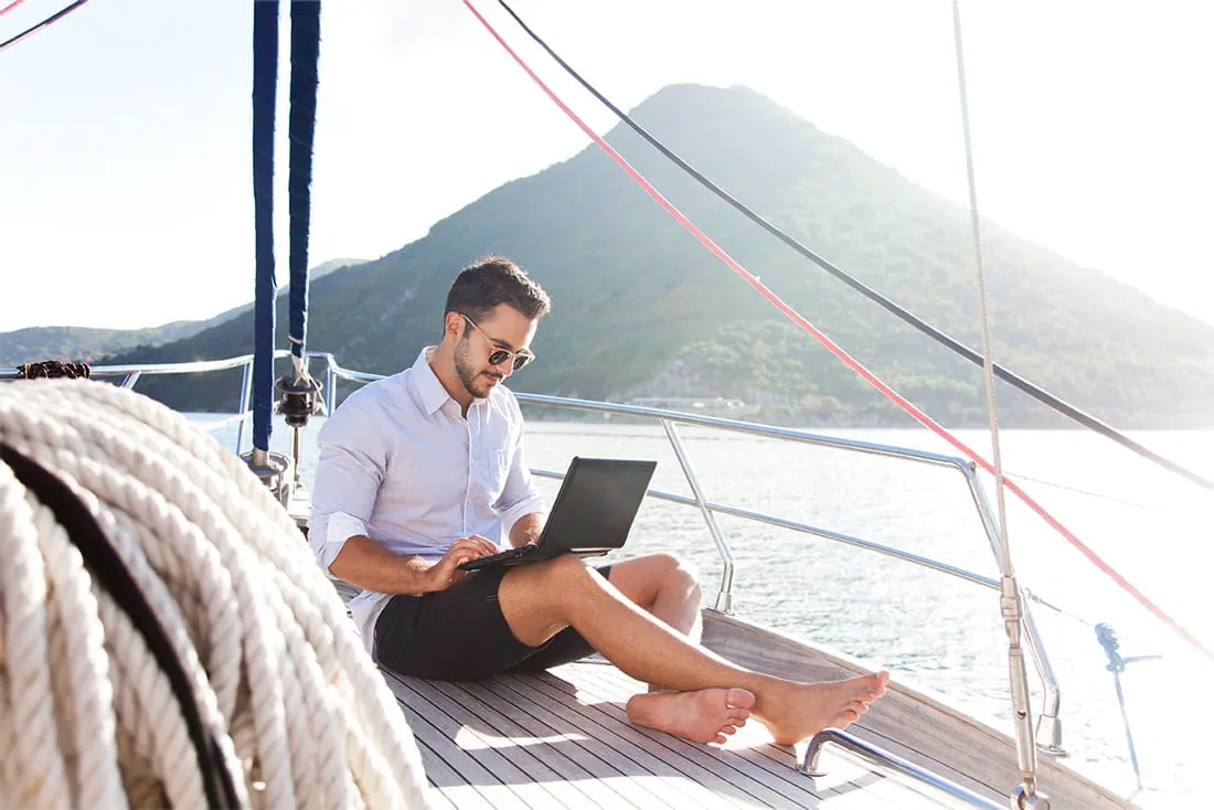 Mann mit Laptop auf einem Boot Mann mit Laptop auf einem Boot