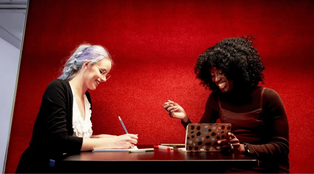 Twee vrouwen zitten aan een tafel Twee vrouwen zitten aan een tafel