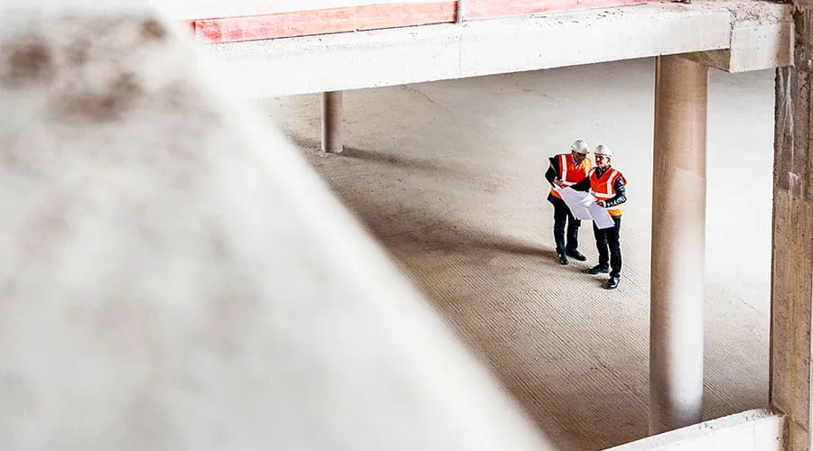 Construction workers inspecting building structure from above Construction workers inspecting building structure from above