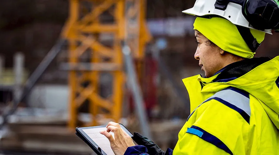 Engineer reviewing plans on tablet at construction site Engineer reviewing plans on tablet at construction site