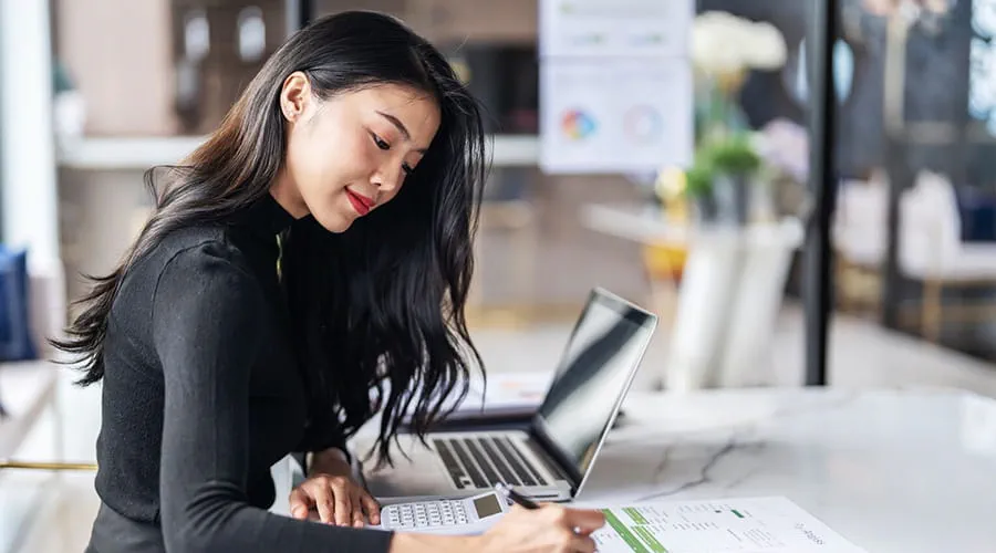 Woman reviewing notes and documents at work Woman reviewing notes and documents at work