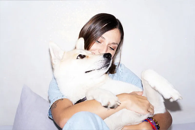 Professional relaxing at home while holding a dog, preparing for a balanced work week. Professional relaxing at home while holding a dog, preparing for a balanced work week.
