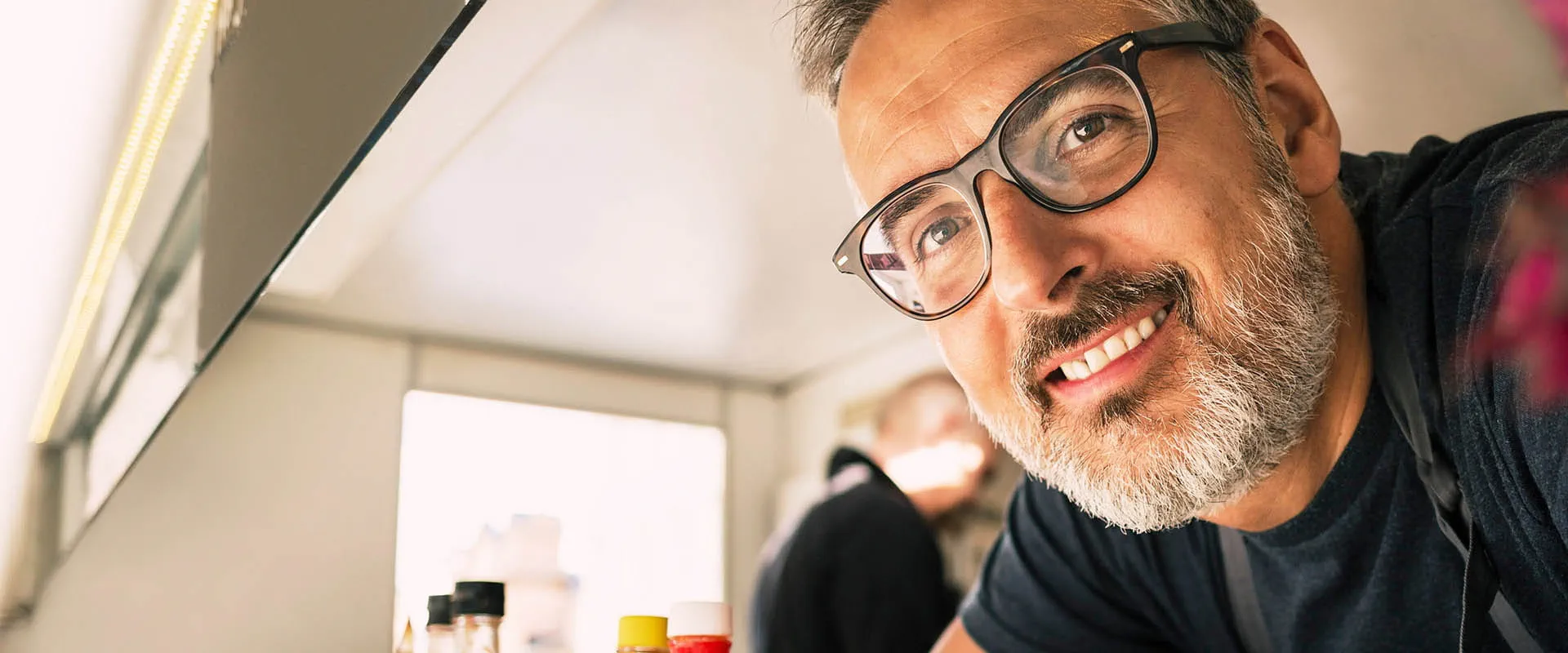 Man glimlacht in een werkruimte binnenshuis Man glimlacht in een werkruimte binnenshuis