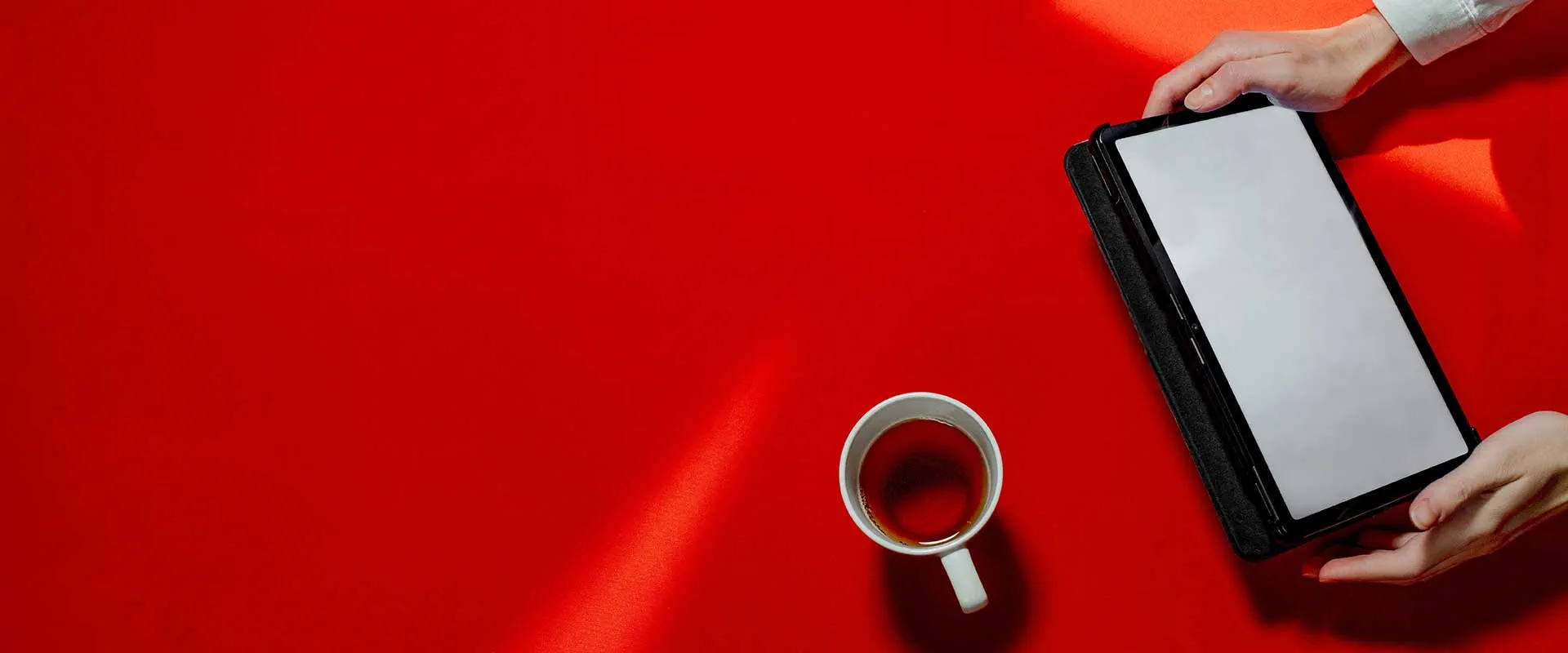 Espacio de trabajo de escritorio rojo con taza de café y tableta visto desde arriba Espacio de trabajo de escritorio rojo con taza de café y tableta visto desde arriba