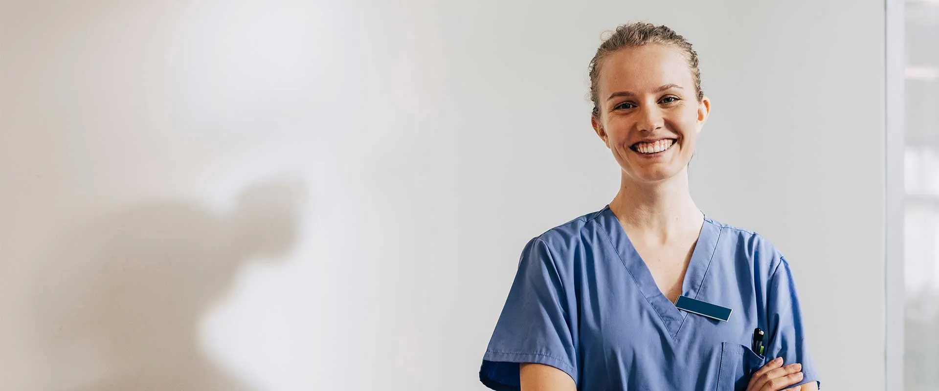 Professionnel de santé en blouse médicale souriant avec assurance dans un environnement clinique Professionnel de santé en blouse médicale souriant avec assurance dans un environnement clinique