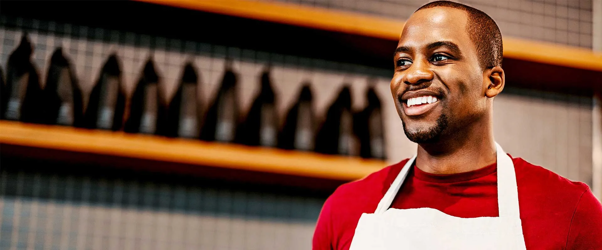 Smiling restaurant worker wearing apron in hospitality setting