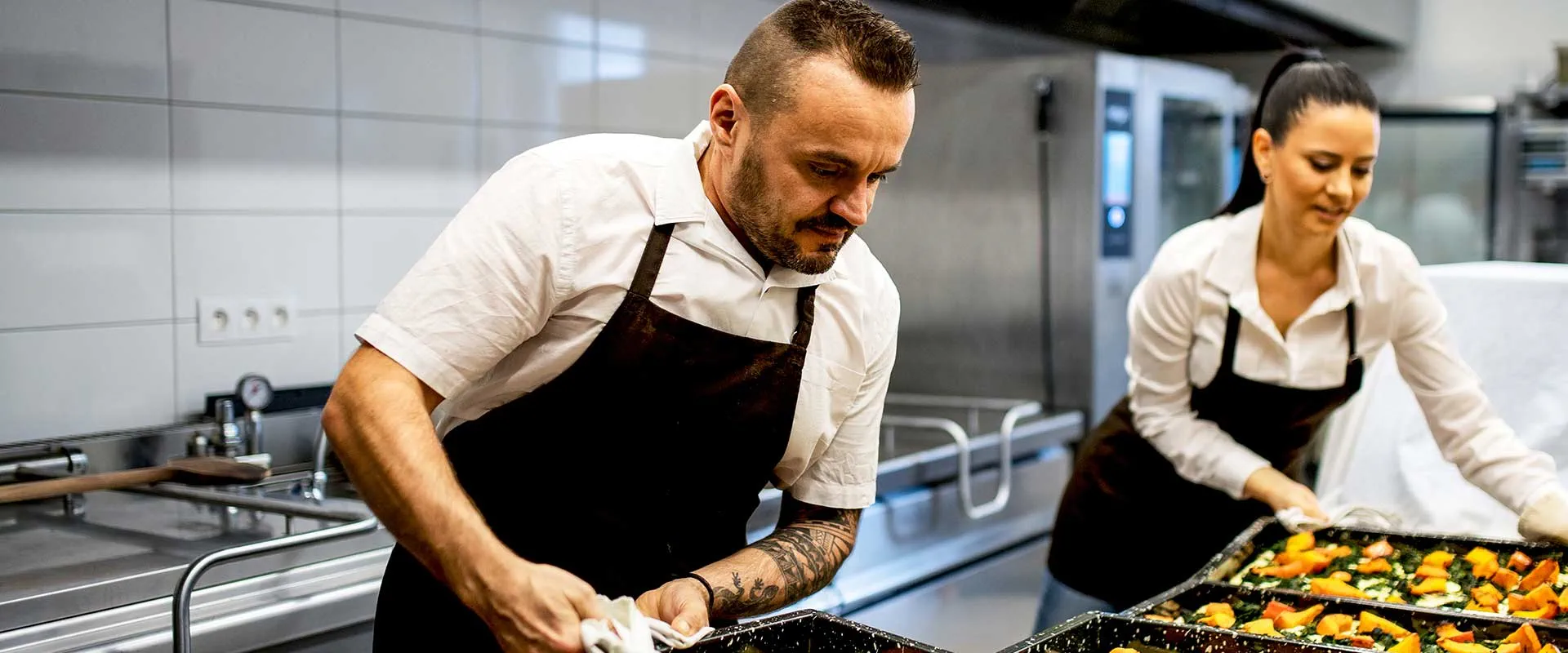 Chefs préparant de la nourriture ensemble dans une cuisine professionnelle Chefs préparant de la nourriture ensemble dans une cuisine professionnelle