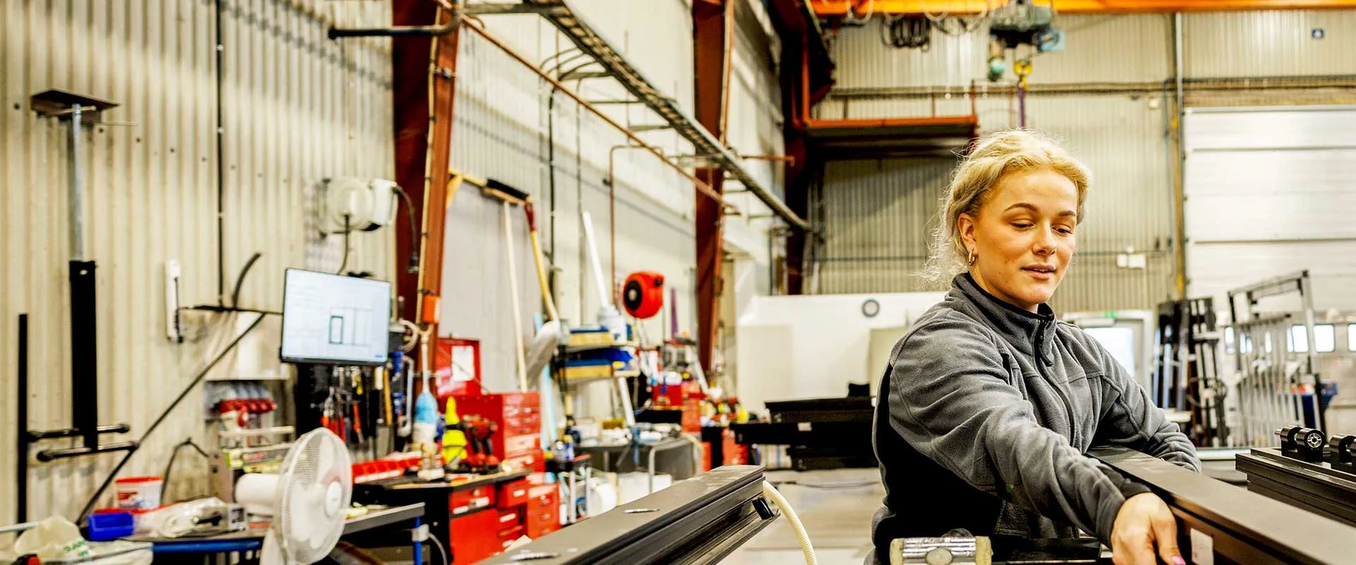 Fabrieksmedewerker bedient apparatuur op productielijn