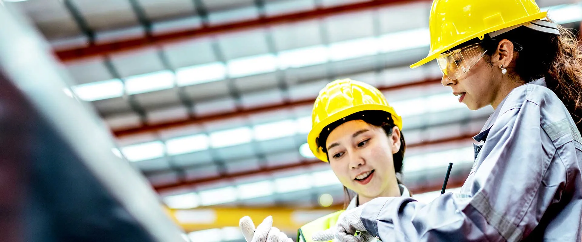 Ingenieurs bekijken plannen in industriële faciliteit Ingenieurs bekijken plannen in industriële faciliteit