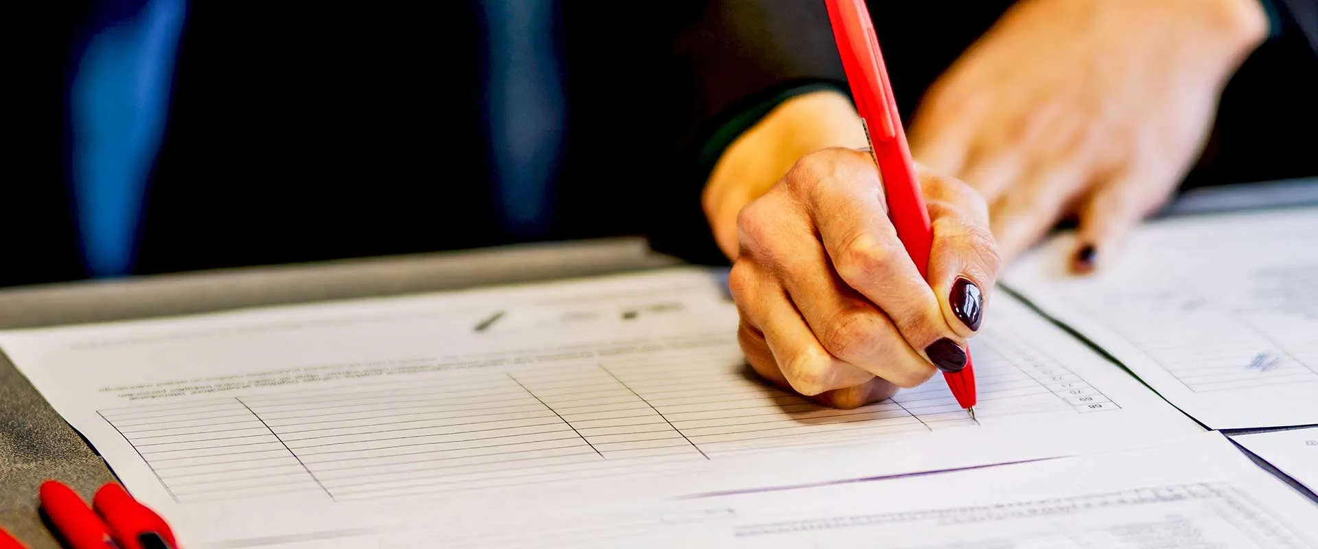 Professional writing notes on document at desk Professional writing notes on document at desk