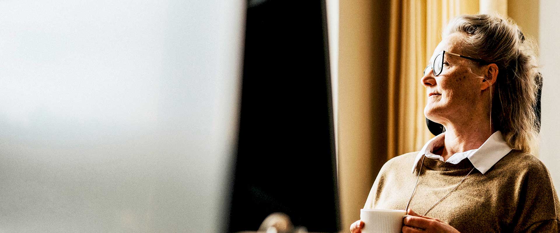 Professional werkt op afstand bij raam met natuurlijk licht Professional werkt op afstand bij raam met natuurlijk licht