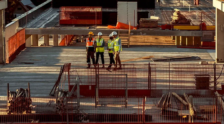 Trabajadores de la construcción colaborando en un sitio de proyecto grande